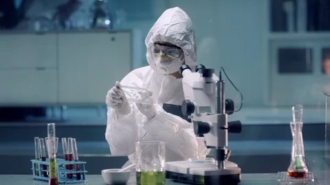 Chemist in a Coverall analyzes DNA on a Transparent Device and Microscope. Shot Stock Footage 119608590