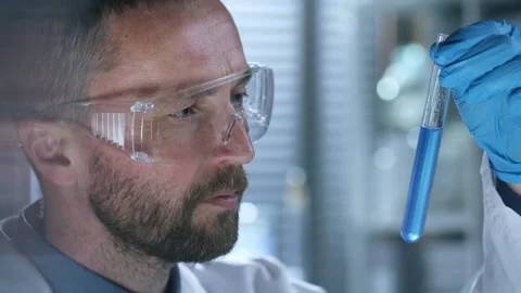 Chemist Examining Blue Liquid in Test Tube during Laboratory Experiment Stock Footage 291250936