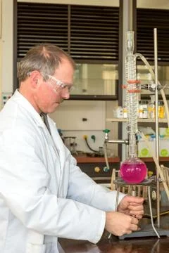 Chemist heating liquid in round-bottom flask Foto stock