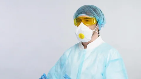 Chemist holding test tubes with reagents and compearing them in protection suit Stock Footage 127037469