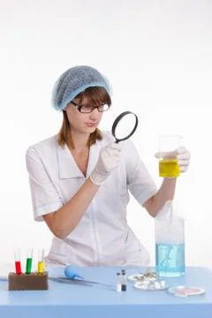Chemist looking at the liquid in flask Foto stock