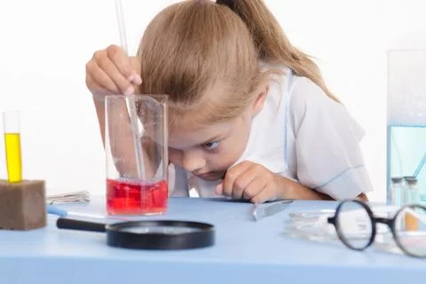 Chemist looking at the liquid in flask Foto stock