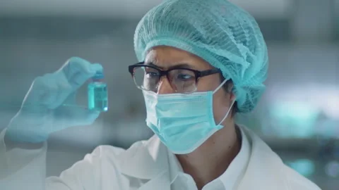Chemist in Mask and Gloves Looking at Vial in Lab Stock Footage 250597749