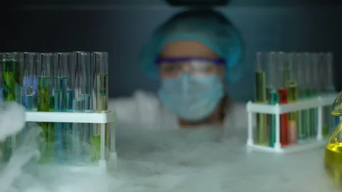 Chemist opening refrigerator and taking green transparent liquid sample, lotion Stock Footage 104987675