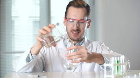 Chemist pouring liquid into flask Vidéo 73111181
