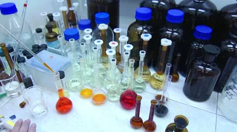 Chemist Pouring Orange Liquid into Flask in Laboratory Stock Footage 11139053