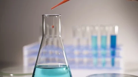 Chemist pours red liquid into a test tube. Conducts a chemical experiment Video stock 120280153