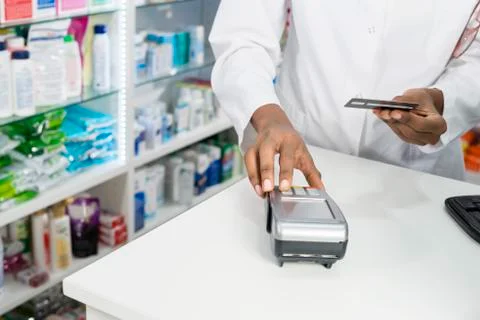 Chemist Pressing Buttons Of Card Reader At Counter Stock Photos