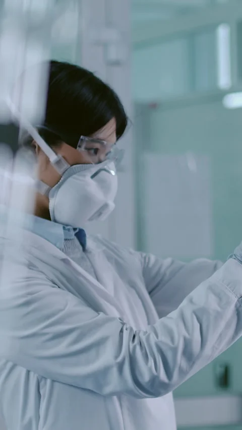 Chemist in Protective Goggles and Mask Examining Toxic Chemical Solution Stockbeeldmateriaal 274232657