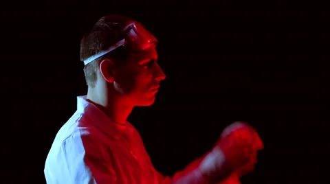 A chemist in the red glow of preparing to carry out experience Stock Footage 48055299