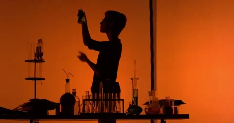 Chemist shakes the flask and writes something Stock-Footage 55567889