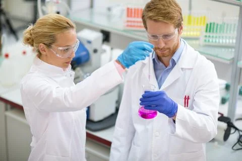 Chemist taking sample from beaker Foto stock