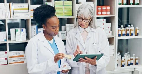 Chemist, team and talk in pharmacy with tablet, check medicine and verify with Stock Photos