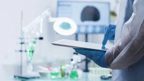 Chemist typing on a digital tablet PC while wearing gloves Stock Footage 113674671