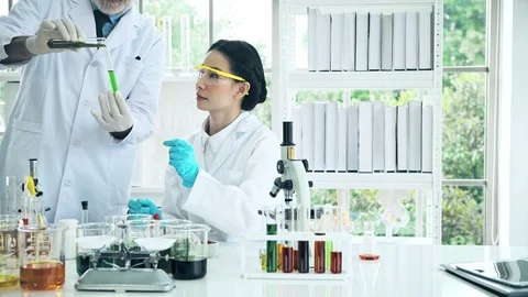 Chemist working in a lab, putting liquid chemical in test tube. Stock Footage 99013799
