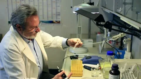 Chemist  working  in a laboratory wiht automatic pipette and vortex Stock Footage 20444555