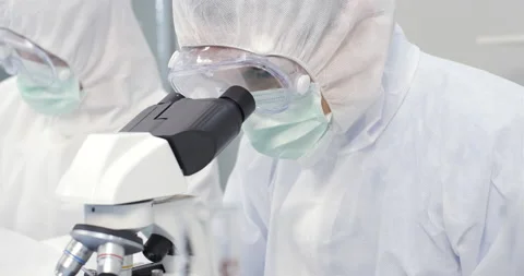 Chemist working with a microscope in laboratory, developing a vaccine Stock Footage