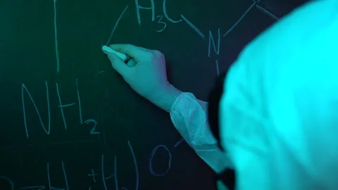 The chemist writes the formula on the blackboard with chalk. Slow motion Stock-Footage 246772912