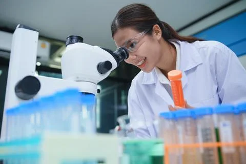 Chemistry Laboratory Scientist Analyzing Samples Using Microscope Fotos de archivo