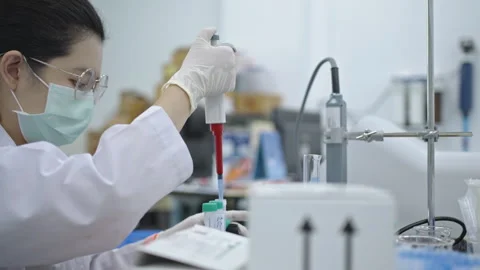 Chemistry research scientist uses a micro-pipette to mix chemicals to test ch Stock Footage 241672553