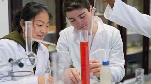 Chemistry students performing titration experiment in university laboratory Stock Footage 302818911