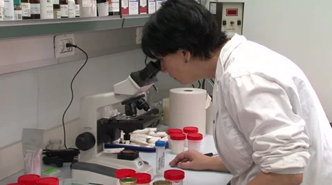 Chemistry tester looking through a microscope Stock Footage 49470877