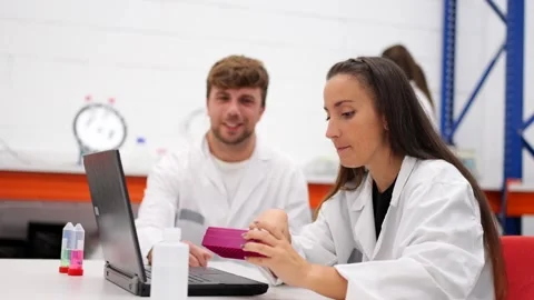 Chemistry workers talking and working on laptop Video stock 255196227