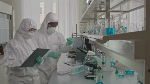 Chemists Analyze Liquid Samples Together in a Modern Laboratory Stock Footage 321379076