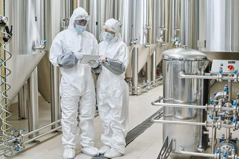 Chemists using tablet pc at factory Stock Photos