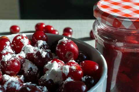 Cherries and a jar of jam on background and fresh fruits on the table, closeup Stock Photos