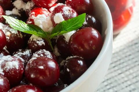 Cherries and a jar of jam on background and fresh fruits on the table, closeup Stock Photos