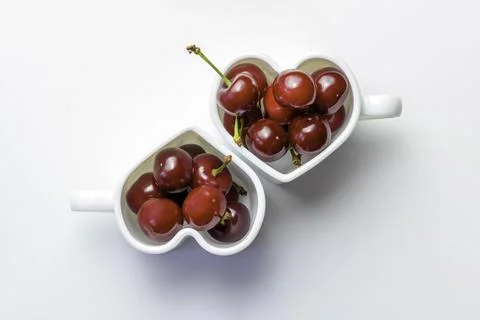 Cherries in a cup on a white background.Heart shape.Flat lay.Copy space, Stock Photos
