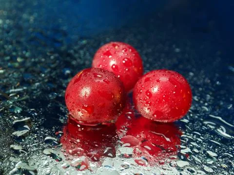 Cherries in the drops on the mirror. Three cherries without cuttings. Stock Photos