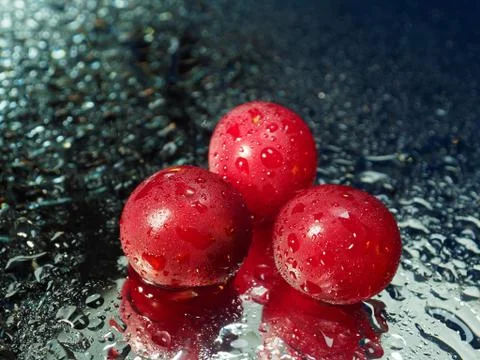 Cherries in the drops on the mirror. Three cherries without cuttings. Stock Photos