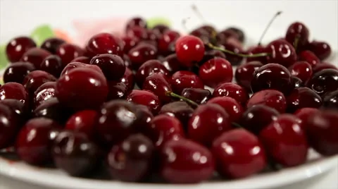 Cherries fall into a bowl on a white background. Stock Footage 61218432