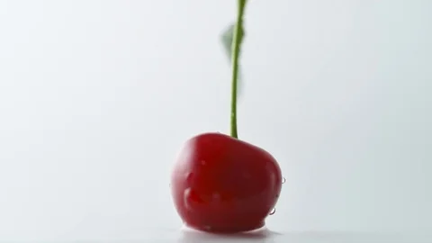 Cherries falling and spinning on water surface. Slow Motion. Stock Footage 79404286