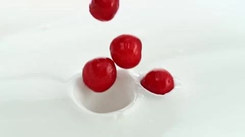 Cherries Falling into Creamy Milk Making Swirly Splashes Stock Footage 274354468
