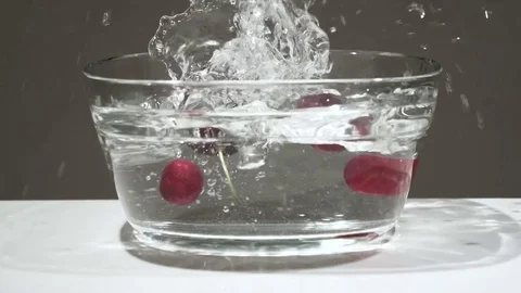 Cherries falling into water in slow motion Vidéo 77002243