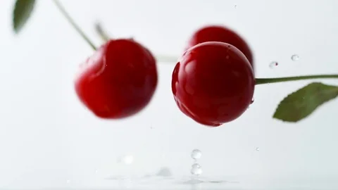 Cherries falling on water surface. Slow Motion. Stock Footage 79477142