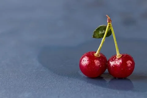 Cherries on grey stone background Stock Photos