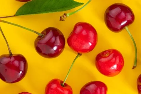 Cherries pattern on yellow background. Top view. Flat lay Stock Photos