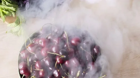 Cherries of red colour lie under liquid nitrogen steam Stock Footage 149556150