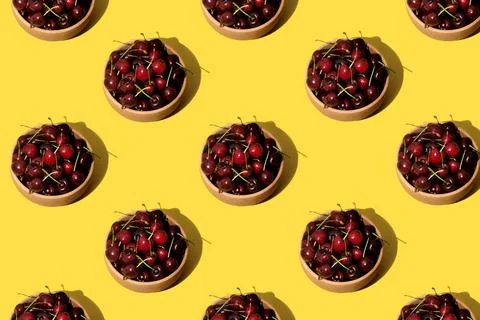 Cherries repetition pattern on yellow background Fotos de archivo
