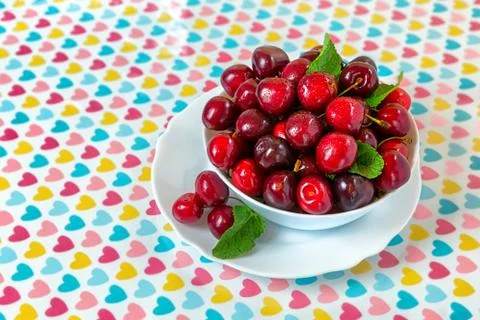 Cherries in a white plate on the table. Stock Photos
