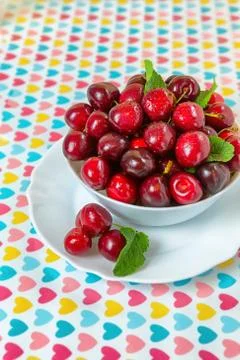 Cherries in a white plate on the table. Stock Photos