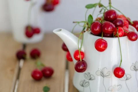 The cherries in white teapot Stock Photos
