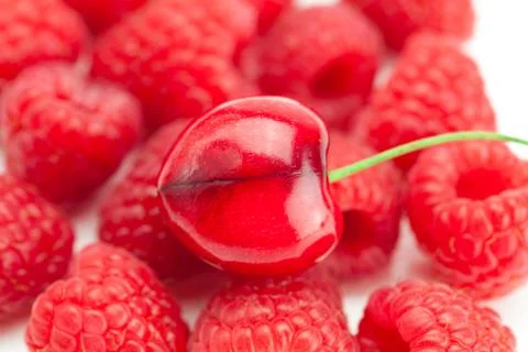 Cherry on a background of raspberry Stock Photos