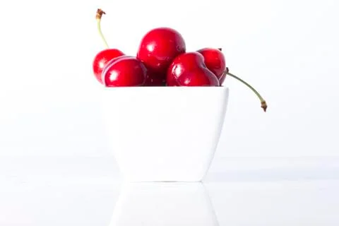 Cherry Berries In A Cup On A White Background Stock Photos