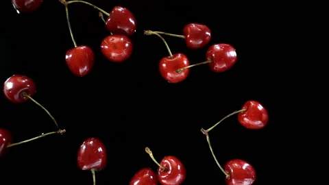 Cherry berries fall in slow motion on a wet black Stock Footage 134243081