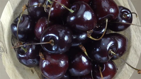 Cherry berries rotate on a wooden plate. Stock Footage 138264853